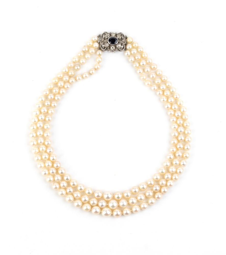 Pearl diamond sapphire gold necklae: Three strands of saltwater cultured pearls, openwork white gold firmness, set with an oval sapphire and rose-cut diamonds.Pearl diameter: 5.5 mm. Length: 44 cm. Weight: 73.2 g.