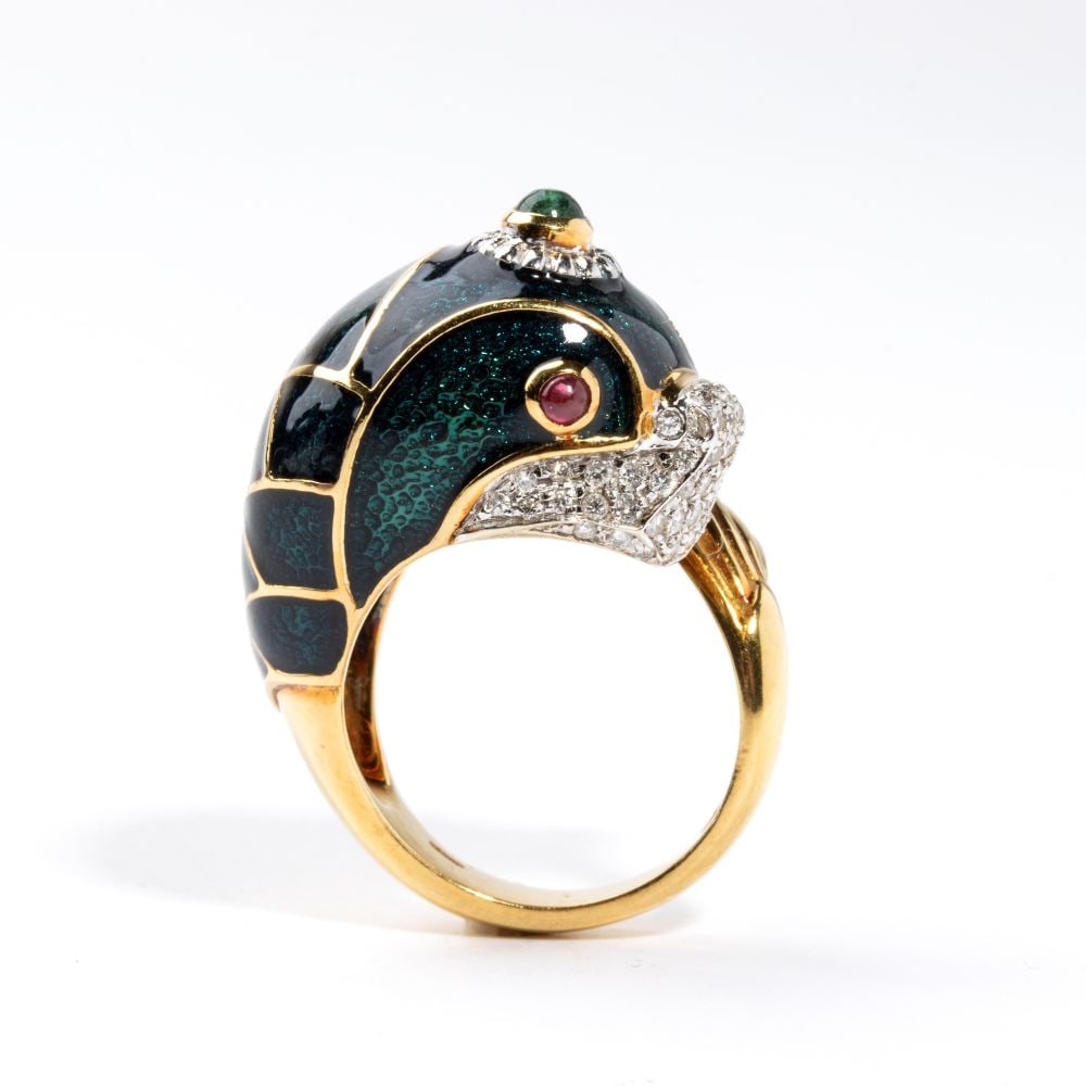 Diamond ruby emerald enameled gold ring: In 18k yellow and white gold, depicting a fish or mythical sea creature with green enamel decorated body, embellished with pavé set diamonds, rubies and emerald cabochons. Round brilliant-cut