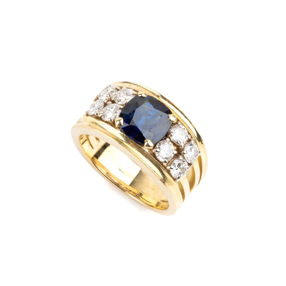 Sapphire diamond gold ring: 18k white and yellow gold band ring, set with a central ova-shaped sapphire flanked by four pairs of brilliant-cut diamonds, estimated total weight of approx. 0.60 ct, colour G-H, clarity VS-SI, as