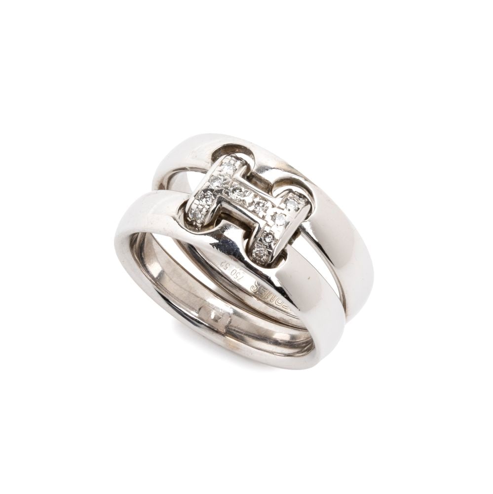 Buckle design diamond gold ring: 18k white gold, set with brilliant-cut diamonds with an estimated total weight of approx. 0.12 ct, colour F-G, clarity VVS-VS, as gauged and graded in the mount.Hallmarked “750 – 52 -