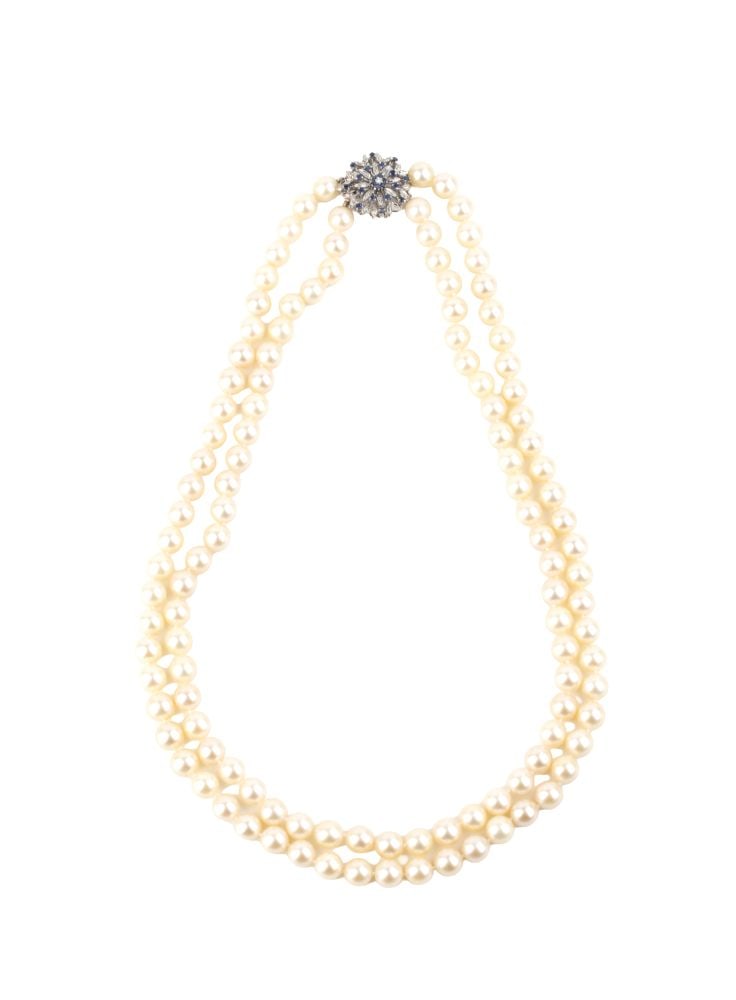Pearl diamond sapphire gold neklace: Two strands of saltwater cultured pearls, 18k white gold flower-shaped clasps, set with sapphires and a diamond.Hallmarked “750 – 803 AL”.Pearl diameter: 7.5–8 mm. Length: 56