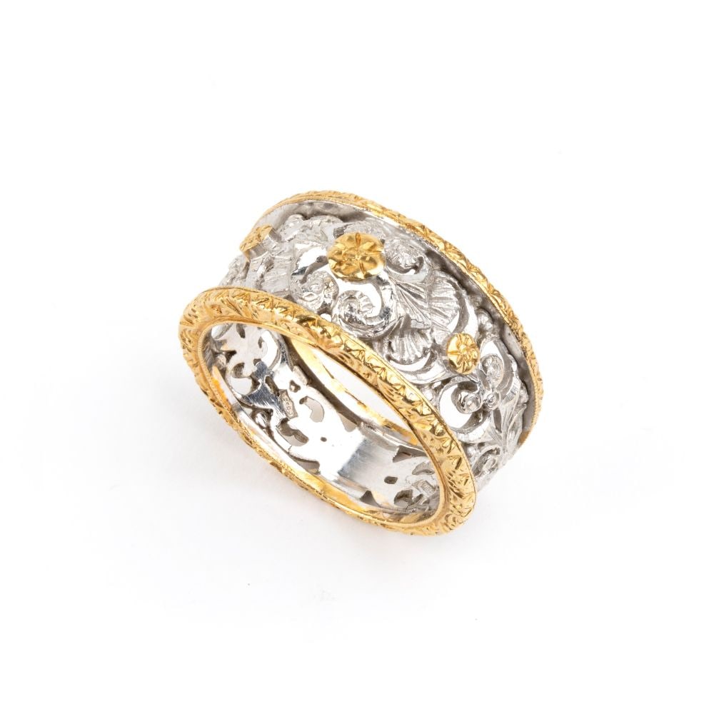 Florentine-style gold ring: 18k yellow and white gold. Openwork inner band featuring a floral garland motif between engraved yellow gold edges.Hallmarked "750 - 551 FI".IT size 15 ½ – US size 7 ½. Weight: 7.9 g.