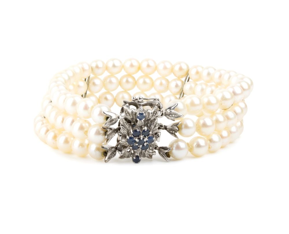 Pearl sapphire gold bracelet: Three strands of saltwater cultured pearls with white gold floral clasp set with sapphires.Pearl diameter: 5.5–6 mm. Length: 19 cm. Weight: 29.3 g.