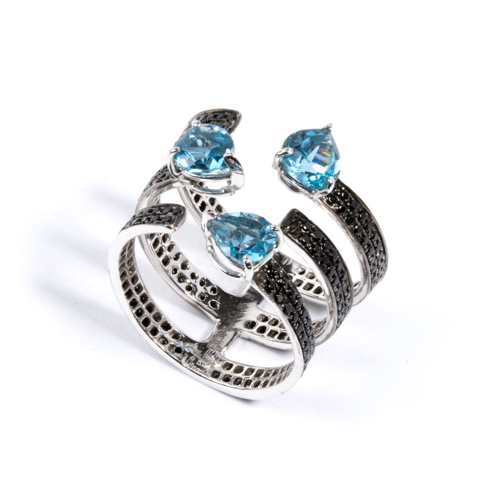 Gold ring with black diamonds and blue topazes: 18k white gold ruthenium plated, designed as a three slender strands band set with of black diamonds, estimated total weight approx. 1.20 ct and three pendant blue topaz.Hallmarked “750”.