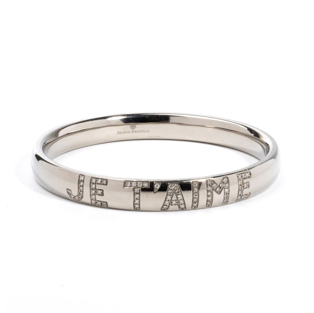 Diamond titanium rigid bracelet: with the inscription "JE T'AIME" in round brilliant-cut diamonds, estimated total weight approx. 0.56 ct, colour H, clarity VS-SI, as measured and graded in the setting. Signed MARTA PAOLILLO.Inner