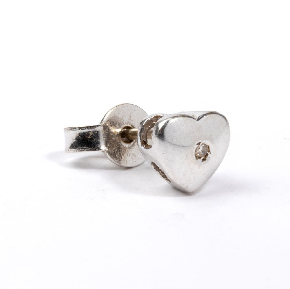 Diamond gold single earring: 18k white gold, featuring the stylised silhouette of an heart, embellished with a round brilliant-cut diamond, weight approx. 0.01 ct. Weight: 1.2 g.