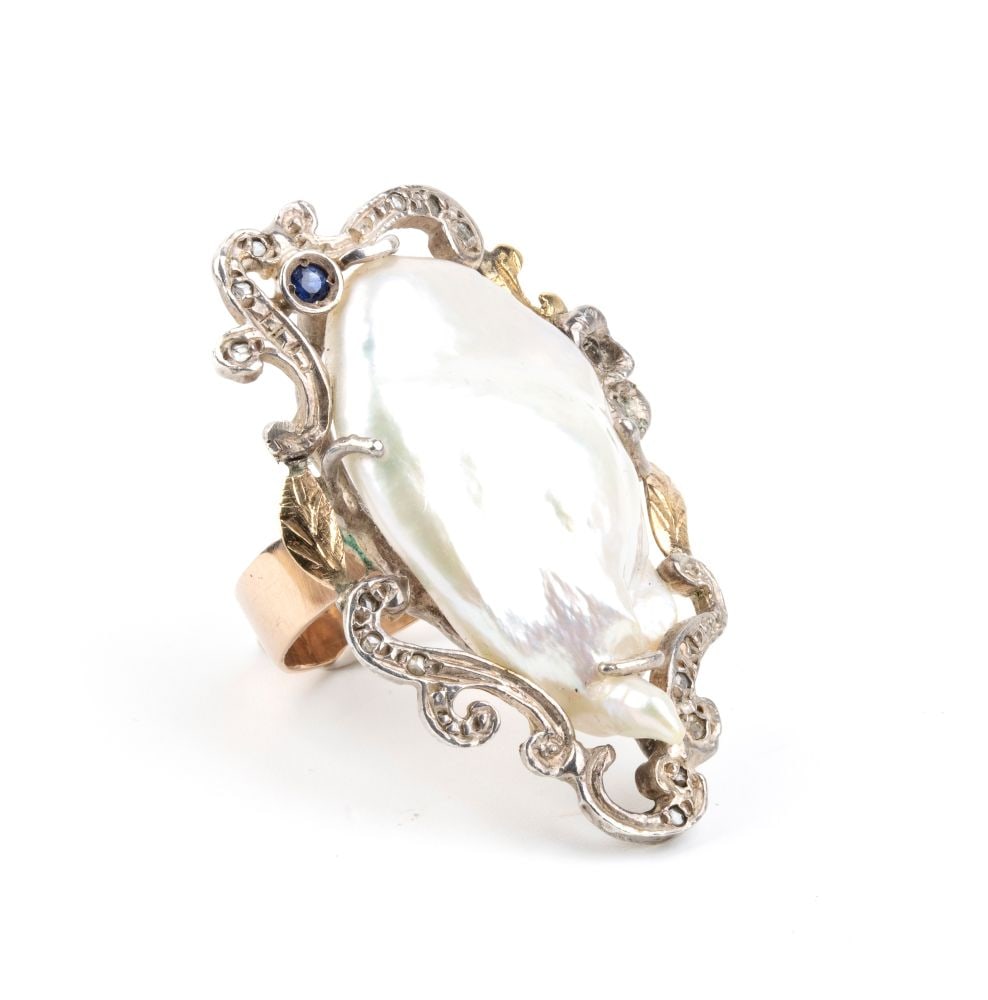 Gold and silver ring with Scaramazza pearl diamond and sapphire: silver and 18k yellow gold, set with a Scaramazza pearl framed rose-cut diamonds and sapphires ribbons.IT size 12 ½ – US size 6 ½. Weight: 15 g.