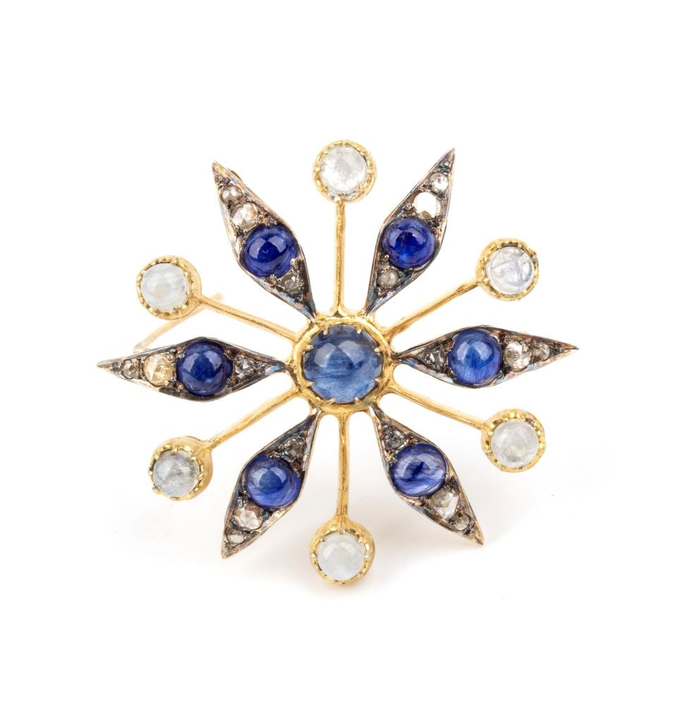 Blue sapphire diamond moonstone stylised flower motif silver and gold brooch: Gilded silver and 14k yellow gold. Set with cabochon-cut sapphires, moonstones and rose-cut diamonds.Hallmarked "585 - 925". Diameter: 4.5 cm. Weight: 10 g.
