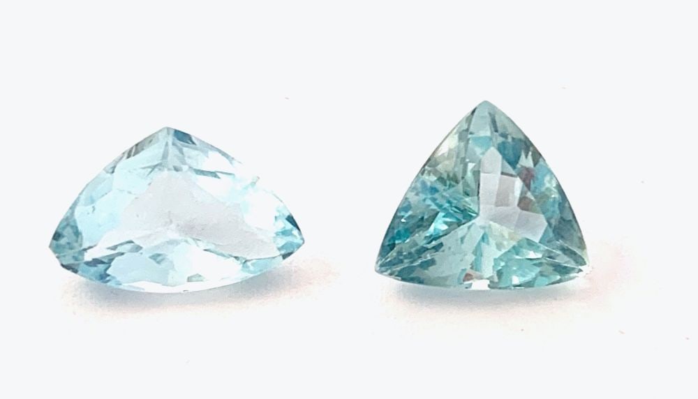 2 natural aquamarines: 2 triangular curved sides shaped, composite cut. Total weight approx. 7.90 ct. Country of origin: Brazil.Dimensions: 10.90 x 11.72 x 6.78 mm; 14.22 x 8.99 x 5.58 mm.