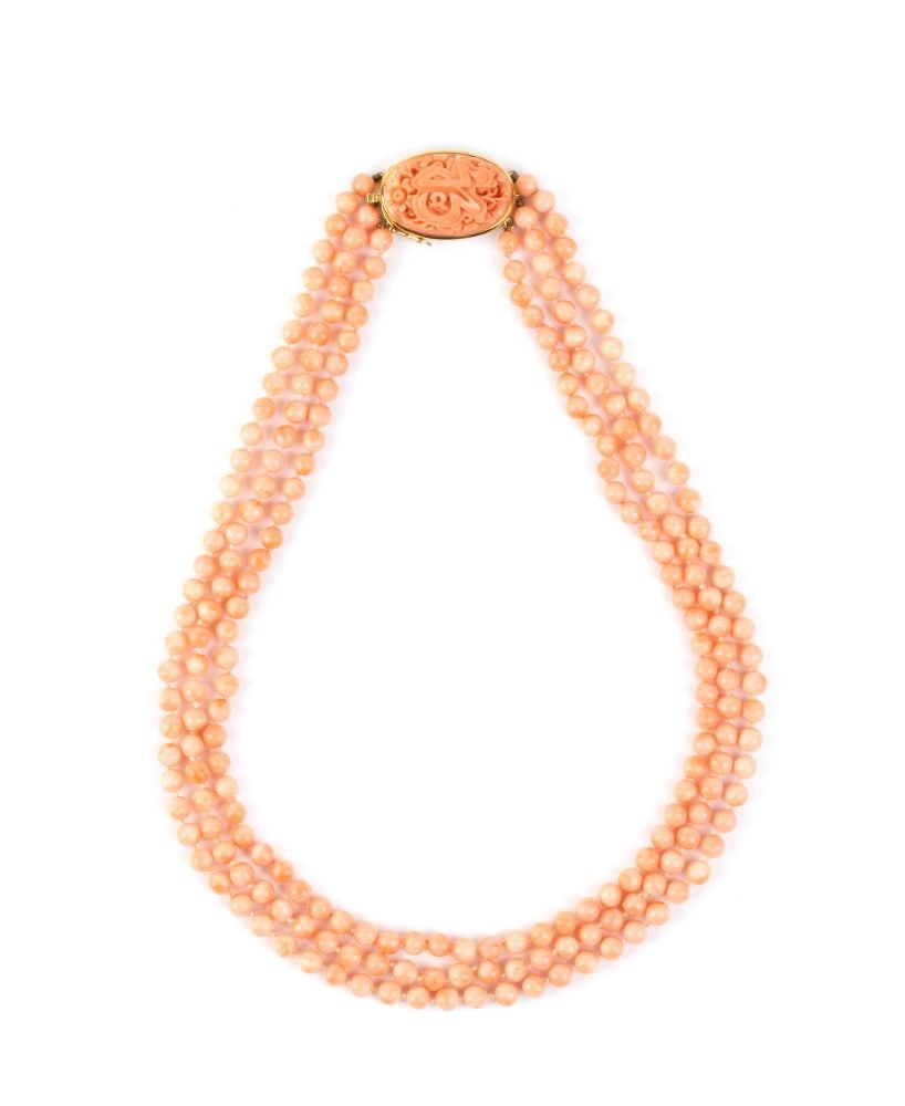 Coral gold necklace: A three-strand necklace of "Deep Sea" coral beads (Hemicorallium lauense), 18k yellow gold clasp, set with a carved floral motif cerasuolo coral (Corallium elatius).Hallmarked “750 – 18k&#