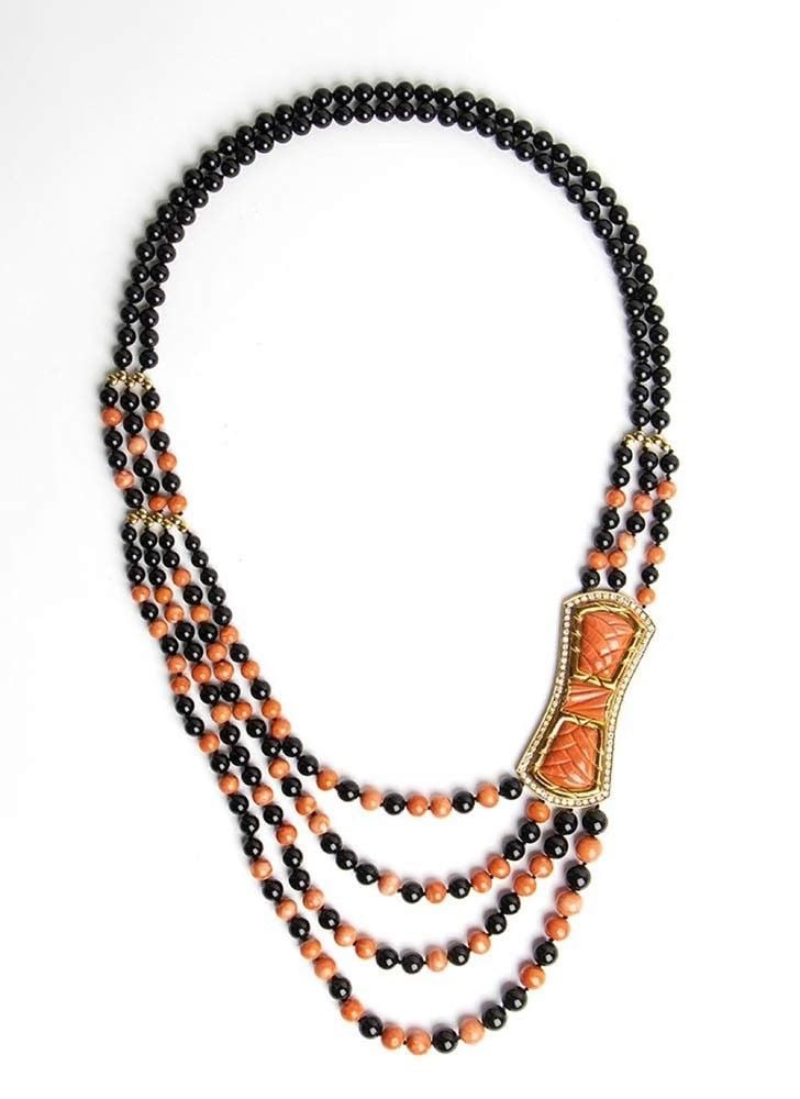 Cerasuolo coral onyx and diamond long gold necklace: two strands of onyx beads with a central section of three strands of cerasuolo coral (coralium elatius) beads alternating with onyx; an 18k yellow gold, ribbon motif, set with engraved coral and frame