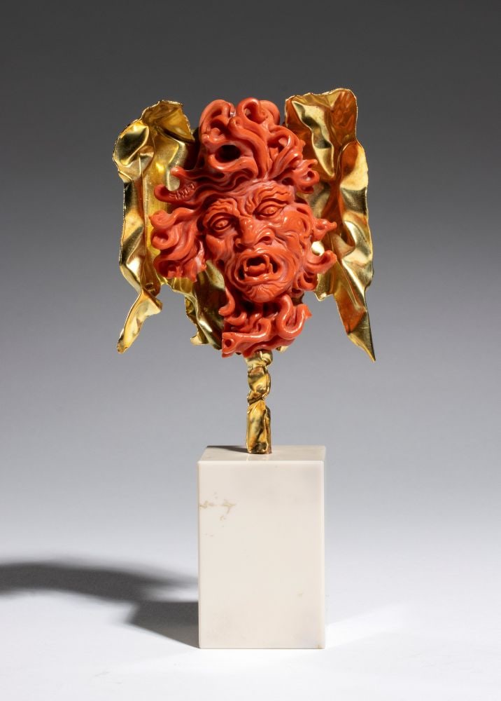 CARLO PARLATI Important coral and gold sculpture depicting the head of Medusa: one of the most iconic mythological subjects in Carlo Parlati's artistic production.The face, carved from a single block of Cerasuolo coral (Corallium elatius) of exceptional chromatic quality, displa