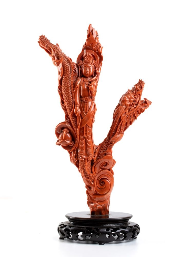 Important Chinese Cersuolo coral carving: Carved from a single piece of "Cerasuolo" coral (Corallium elatius) of reddish-orange hue, depicting Guanyin, the iconic symbol of grace, virtue, and ideal beauty.Guanyin is portrayed at the center of