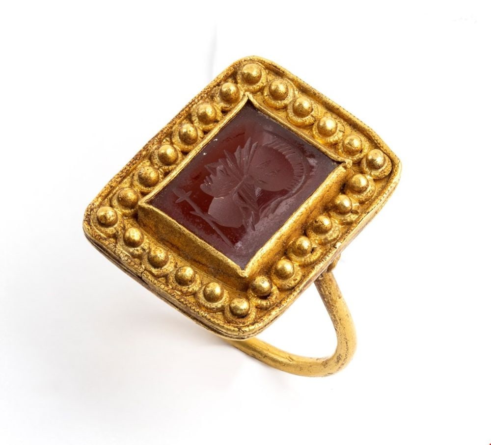 Archaeological-style gold and carnelian ring: made by an hight fineness gold, rectangular shaped, set with a carved carnelian depicting a classic warrior head framed by gold grains. IT size 27 - US size 12. Front dimensions: 2.7 x 2.3 cm. Weight:
