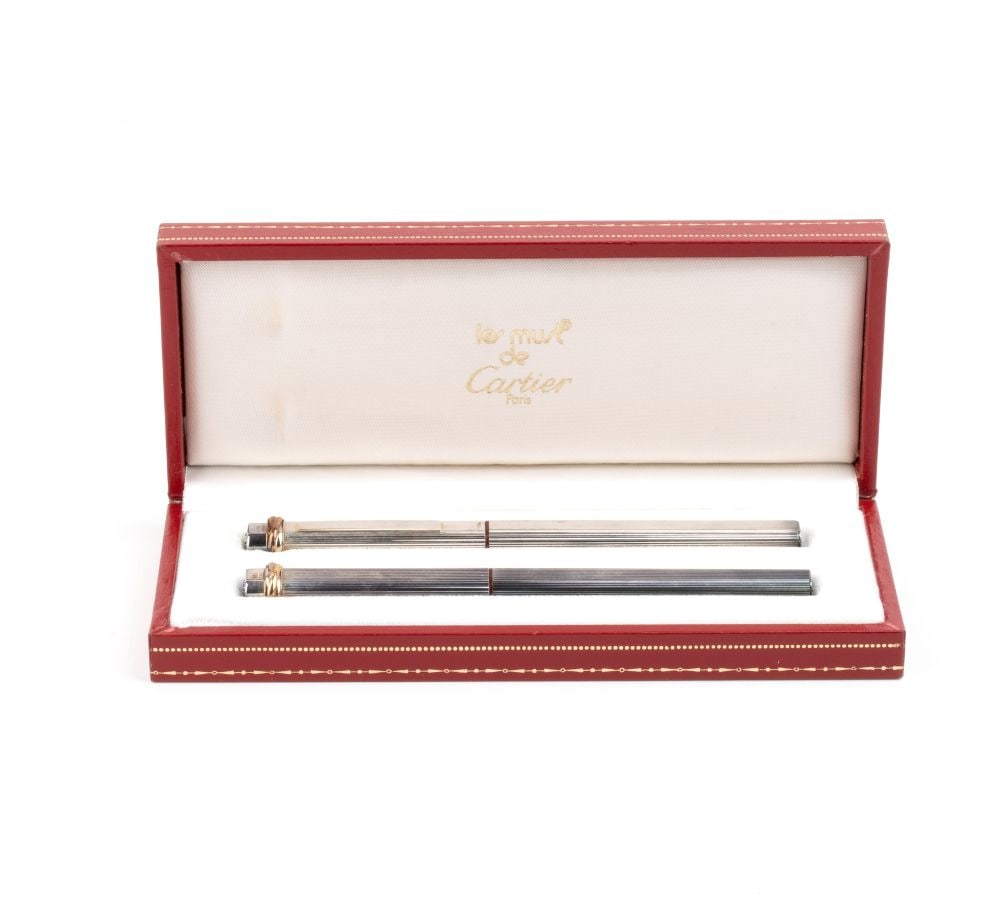 CARTIER A pair of pens: consisting of a fountain pen and a ballpoint pen, with a tapered barrel and cap; pressing the top of the cap causes the clip to open to the desired width, and releasing the pressure causes the clip