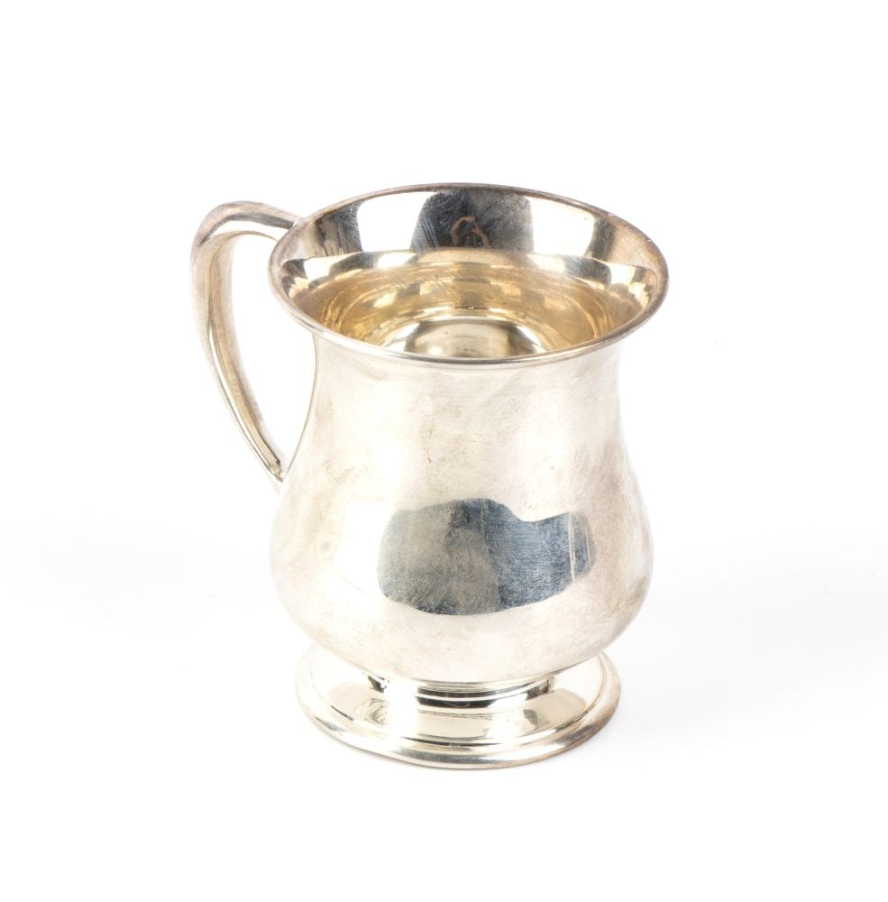 TIFFANY & CO.® American sterling silver mug: Height x width x depth: 9 x 10 x 7.5 cm. Weight: 160 gcharacterised by a rounded balustrade-style silhouette with a flared rim, a moulded circular base and a scroll-shaped handle. The surface is
