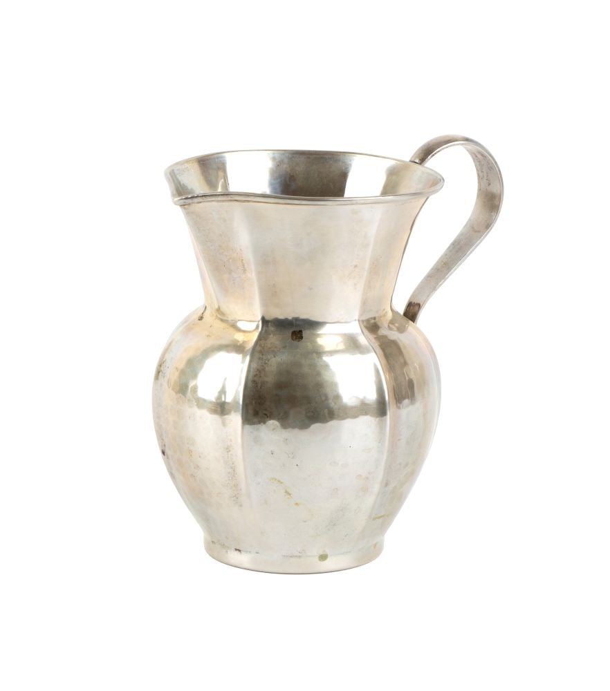 Italian solid slver jug: with a smooth, contoured body bearing hammer marks.800/1000 silver, hallmarked "BATTUTO A MANO - 800 - 29 PO".