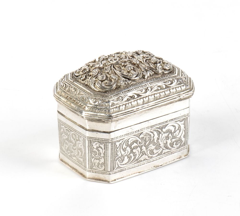 Solid silver box: crafted using repoussé and chiselling techniques, with a slip-on lid, characterised by intricate workmanship. The box features an elegant octagonal shape with rounded corners. The object is