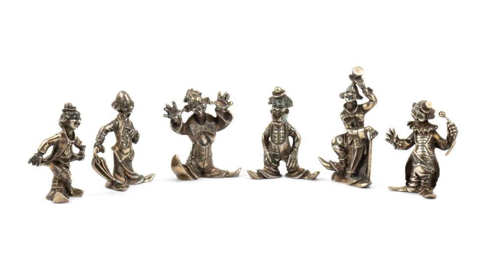 Set of 6 Italian solid silver place cards: in the shape of clowns captured in different but dynamic poses.800/1000 silver, hallmarked ‘800’.Heights ranging from 6 to 7.5 cm.