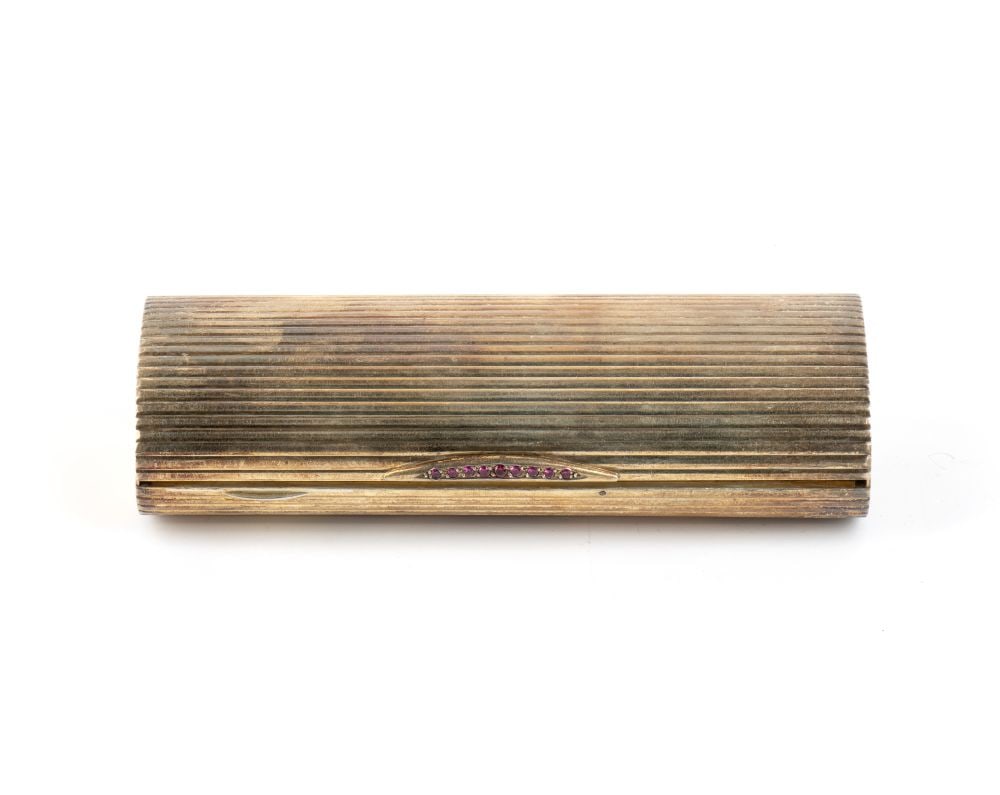 Art Deco Evening Toiletry Bag in Vermeil Silver: cylindrical in shape. The exterior is entirely decorated with a pattern of dense horizontal grooves, with the side ends engraved with a radiating motif. It features a snap fastening embellished with