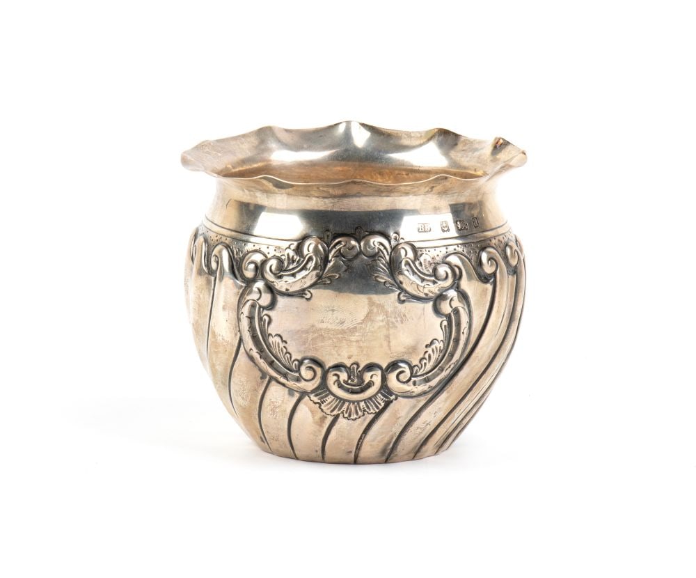 BARKER BROTHERS SILVER Ltd Sterling silver English vase: rounded body with a flared, undulating upper rim. The surface is embellished with a refined relief decoration consisting of deep vertical grooves running the length of the vase. On the front is a