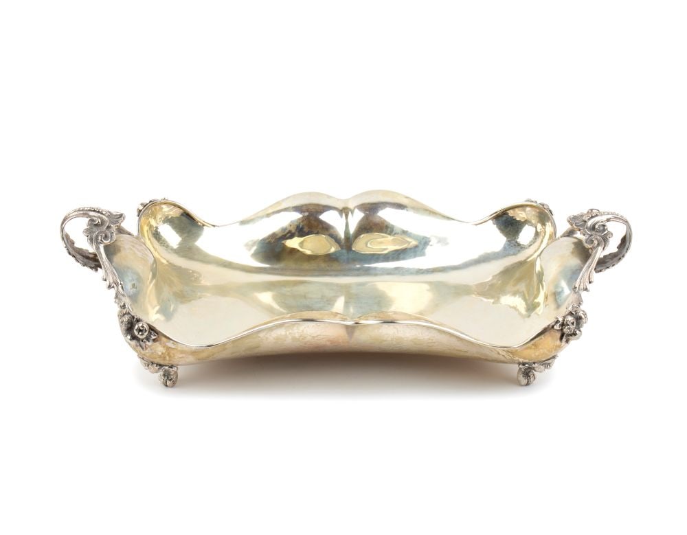 Silver basket: rectangular in shape, with floral motifs at the corners and resting on four legs in the shape of stylised leaves.800/1000 silver, hallmarked "800".