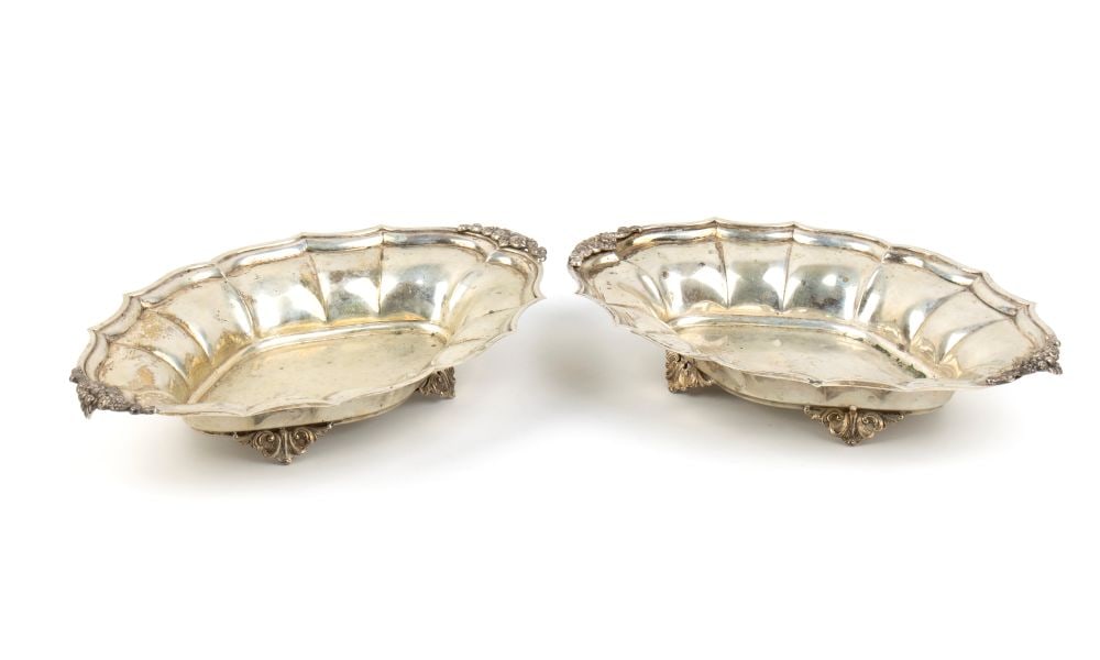 A pair of italian solid silver baskets: oval in shape, resting on four leaf-shaped feet, with side handles shaped like baskets of fruit and flowers.800/1000 silver, hallmarked "800"