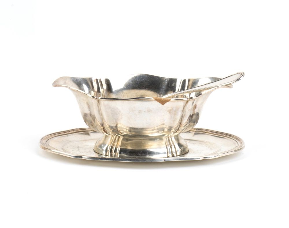 Italian solid silver gravy boat: oval shaped, on a smooth base, resting on a oval tray. Comes with a spoon.800/1000 silver, hallmarked "800 - 1 AL".Height x width x depth: 8 x 23 x 13.5 cm;Height x width of spoon: 15.5 x 7 cm.