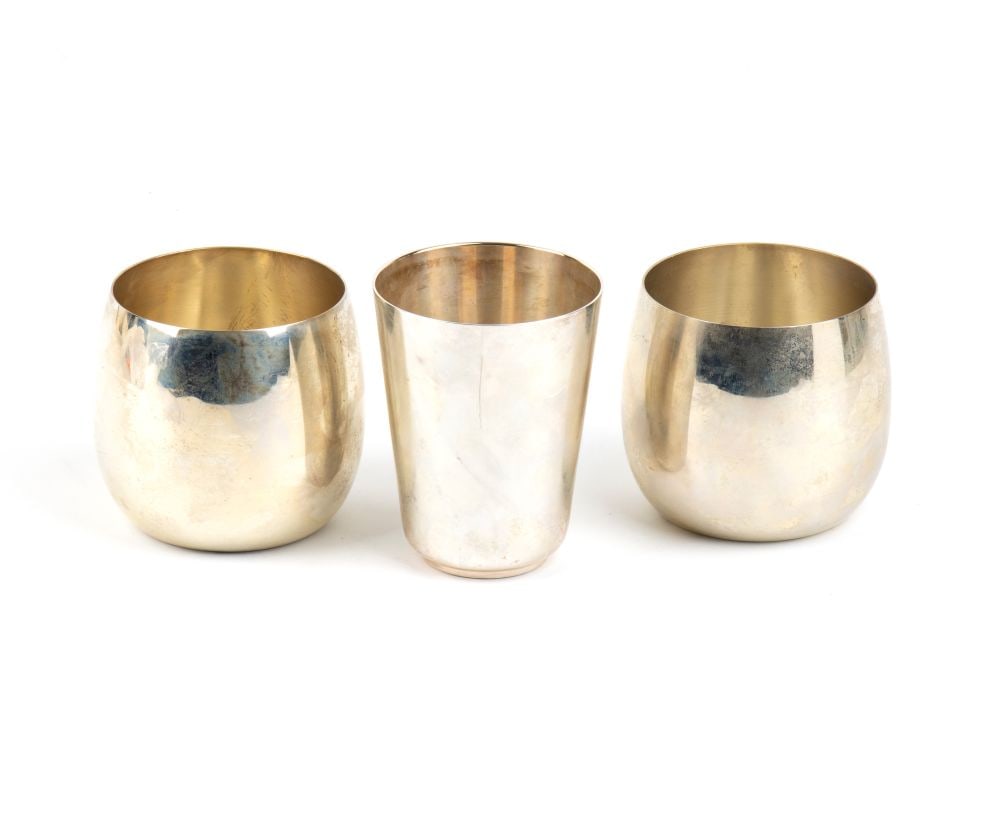 A group of 3 italian solid silver glasses: comprising two flared glasses and one taller glass, all with smooth bodies.sterling silver, hallmarked ‘925 – 39 MI – FC’ and ‘800 – 30 PD’.Height ×