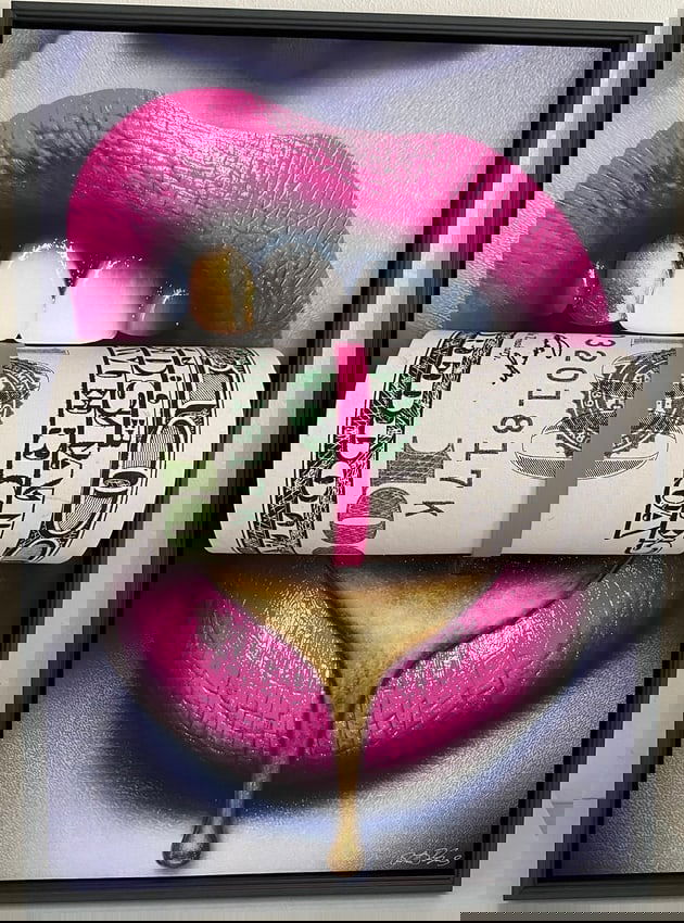 3D Sculpture of Pink Money Lips: 3D Sculpture of Pink Money Lips: Material resin and wood.3D money roll popping out of canvas clenched in mouth with sexy hot pink lips with a gold tooth and gold drip from lower lip, framed in black f