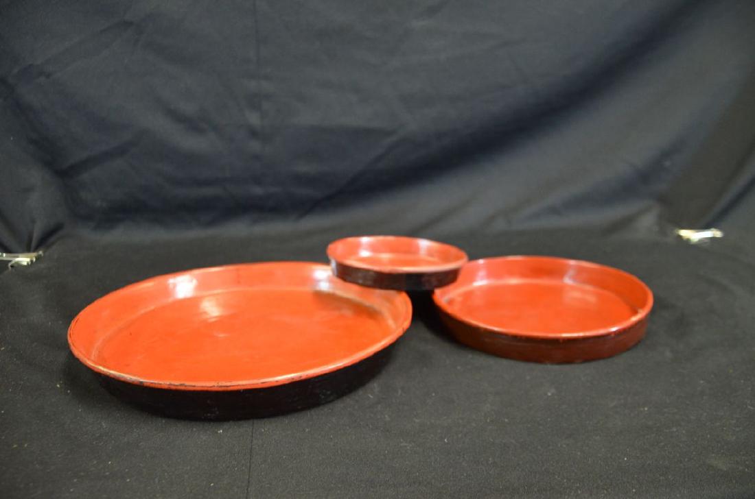 Lot de trois assiettes en laque rouge, pourtours peints (1 of 2)