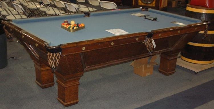 Massive Wood Pool Table: This distinct pool table in massive wood features leather pockets and solid wood rails in a beautiful chestnut finish. Applications in brass and chrome. Cloth in light blue. style of furniture. In the