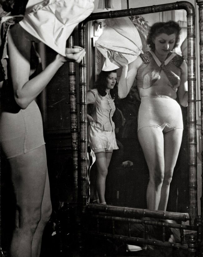 Brassaï: Women dressing: Women dressing in front of mirror. Late 1930s. Vintage ferrotyped gelatin silver print. 29 x 22,7 cm. Photographer's 81, rue du Faub St. Jacques Paris XIV stamp, annotated Pl. 662 by Brassai in in