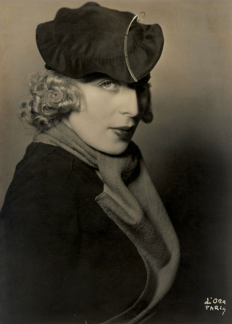D'Ora: Portrait of Tamara de Lempicka: Portrait of the painter Tamara de Lempicka (1898 - 1980). Early 1930s. Vintage, ferrotyped, warm-toned gelatin silver print. 22 x 16,8 cm. Signed by the photographer in lower right corner in the negat