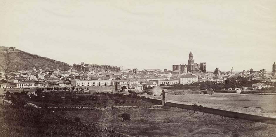 Clifford, Charles: View of Malaga: View of Malaga. Circa 1860. Albumen print. 18 x 36 cm. Mounted in edges to card, annotated Malaga in ink below the image on the mount.Some buckling from mounting in edges, minimal fading in right edge