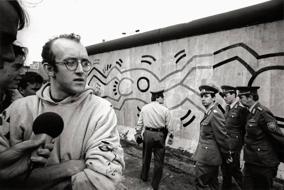 Haring, Keith (Vladimir Sichov): Keith Haring, Be: Photographer: Vladimir Sichov (b. 1943). Keith Haring, Berlin Wall painting project. 1986/printed later. 2 semi-glossy gelatin silver prints. 27 x 40 cm (39,5 x 50 cm) and 30 x 45 cm (39,5 x 50 cm). E