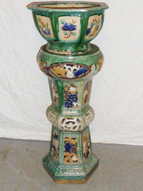 ORIENTAL GLAZED POTTERY JARDINIERE AND PEDESTAL: SHOWING A ORIENTAL GLAZED POTTERY JARDINIERE AND PEDESTAL . PIERCED CARVINGS , DECORATED WITH MULTI COLORED FLOWERS . MEASURES 38" TALL AND 14 1/2" WIDE . AS FOUND ESTATE CONDITION.PLEASE USE PHOTOS A