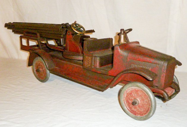 Buddy "L" Pressed Steel Aerial Ladder Fire Truck 1920's: Comes with three ladders, original paint and bell. Moline Pressed Steel Co.. Measures 30" long. As found estate condition . Please use photos as part of the description. The absence of a condition rep