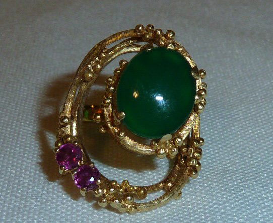 18kt Imperial Jade with Rubies Artisan made Ring: 18kt yellow gold swirls in a upward motion with two rubies and gold beads culminating with a oval emerald center stone. Size 6 1/2. As found estate condition . Please use photos as part of the descrip