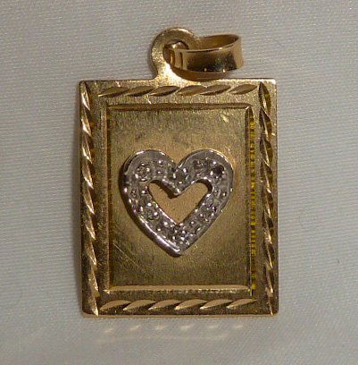 14kt Gold Pendant w/ Diamond Raised Heart Charm: Measures 5/8" wide by 3/4" tall. Pendant in the shape of a etched frame with raised diamond heart in center of frame. Solid 14kt yellow gold. Over 12 hard to find movable gold charms in this sale. As