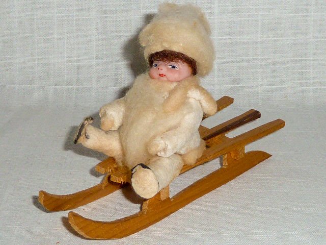 Victorian Wax Christmas Ornament "Girl on Sled": This lovely Victorian Christmas ornament has a wax face with cotton and felt clothing . She is siting on a hand made sled. Measures 6" long. Pristine condition no damage. As found estate condition . P