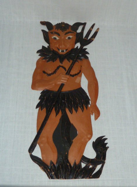 Early Halloween German Die Cut Embossed Devil: Antique Halloween Die Cut Devil. Devil is Marked made in Germany and dates to early 1900's. Unused Easel Back. Heavily embossed. Measures 19 1/2” tall. Condition is good for age with some minor crea