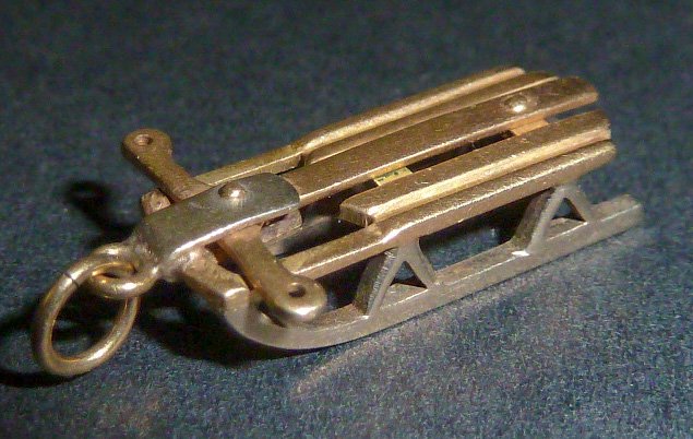 14 Kt. Gold 3 Dimensional Sled Charm: 14 Kt. Gold Charm Of Sled is quite remarkable in it's design, made of two tone , white and yellow gold , riveted and steers just like a normal size . Slides in at 1 dwt. Measures 7/8” long by 7/16��