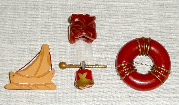 Vintage Bakelite: Sailboat, Majorette Pin, Ring, Brooch: Very nice lot of four distinctive vintage Bakelite pieces : 1. Butterscotch Sail Boat pin measuring 2” by 2” at top of sail. 2. Rare / Scarce Majorette Cap in red with Baton clasp, all original an