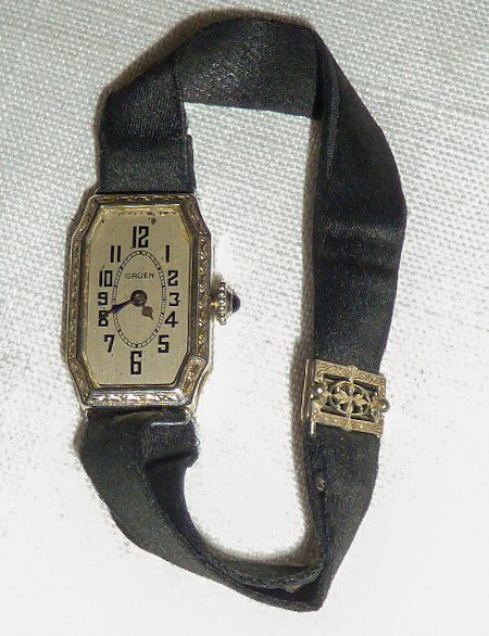 1920's Art Deco Ladies Gruen Wrist Watch: Gruen ladies wrist watch with fancy elongated octagonal shaped case. Case is marked "Gruen 14kt Gold filled reinforced with extra gold Wadsworth" . Satin strap band with filigree clasp. What a beauty