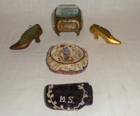 1800's 5 Sewing Items: Pin Cushion w/ McKinley Pin Etc.: 1800's Early Sewing Items. Five Items In Lot: 1893 World's Fair Sewing Box with Hand Painted Top. Top has some wear. Box Is crystal & footed measuring 3” by 3” with brass trim. Original Cotton Pin