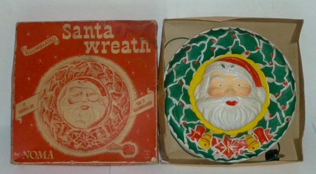 Noma Illuminated Santa Wreath W/ Original Box: Illuminated working Noma Santa wreath. Catalog Number 1130,measuring 12 1/2" diameter in original box measuring 12 3/4" by 12 3/4". Box shows wear. Original price $1.59. Will light up your Christmas H