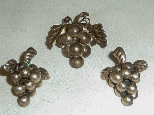 Vintage Taxco Mexico Sterling Silver Grape & Leaf Brooch Pin And Earring Set: This lovely grape cluster brooch/pin is part of a set with matching earrings. Signed on back Taxco Mexico 925. Brooch measures 1 1/2" wide by 2" in length. Earrings measure 1 1/4" by 1 1/4". I see kno