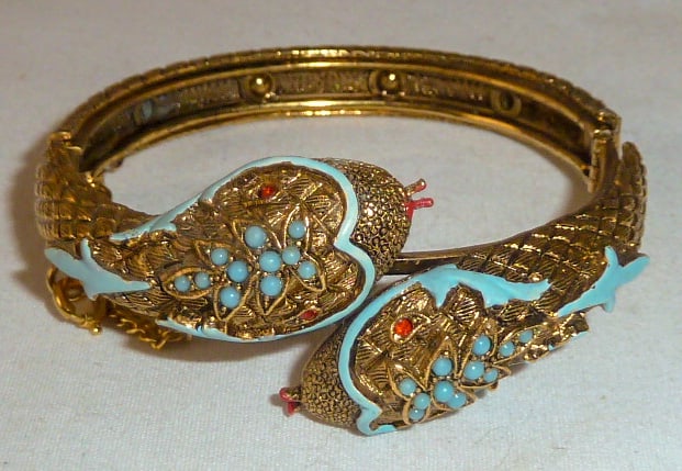 Vintage Double Headed Enameled Snake Bracelet: Gold Tone Hinged Cuff Bracelet has an intricate design running the full length of the bracelet and the double snake heads are beautifully decorated. Bracelet has a security chain. Measures 2 1/2" acro