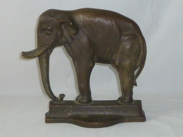 Bradley & Hubbard 7799 Elephant Doorstop: Elephant stands on a platform with trunk up. Terrific detailing as you would expectâ€¦ Measures 10 1/4" tall base is 9 1/2" wide and 2 5/8" deep. Back is marked B.&.H 7799. All original and elegan
